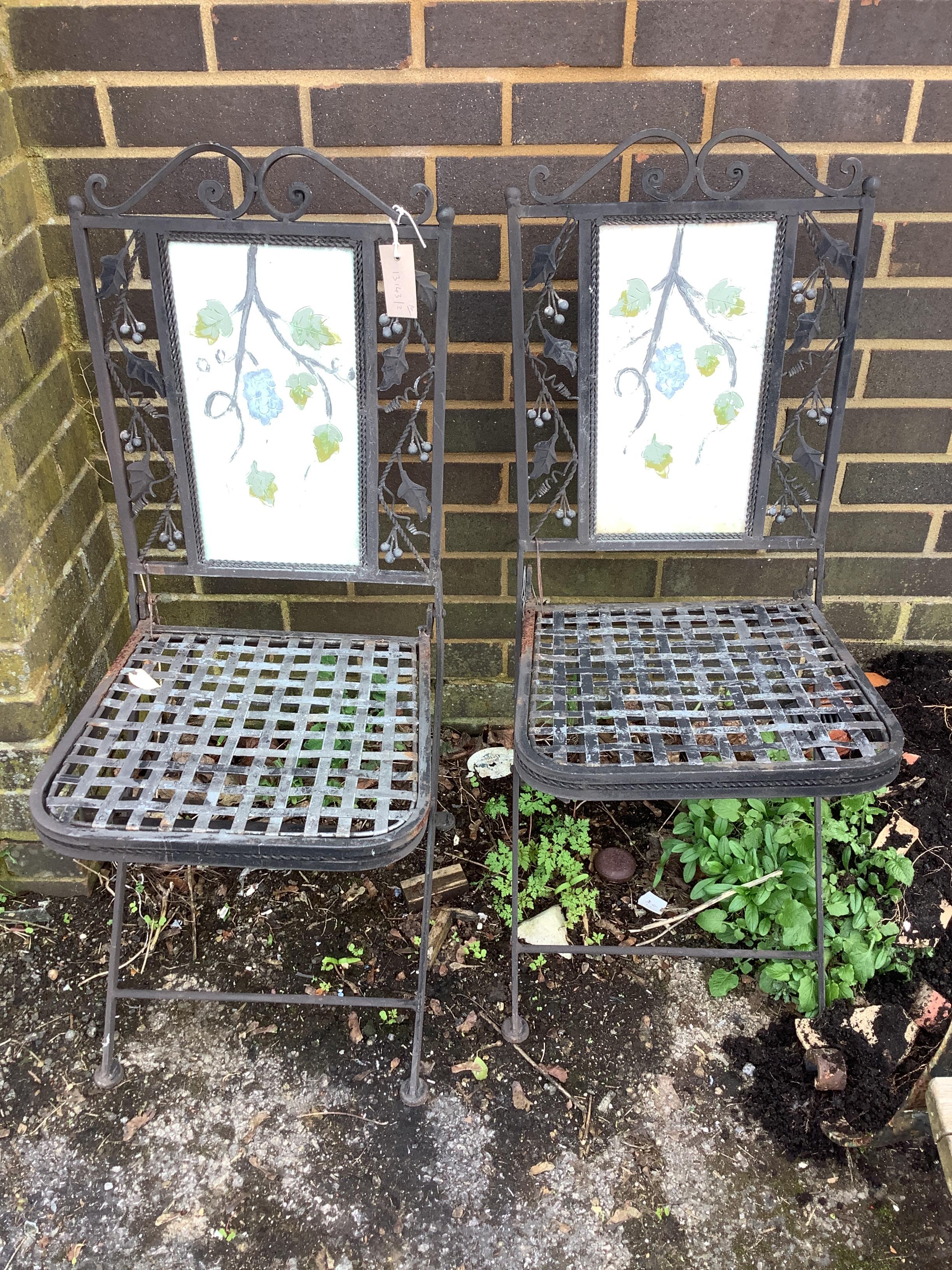 A pair of folding painted metal garden chairs with lattice seats